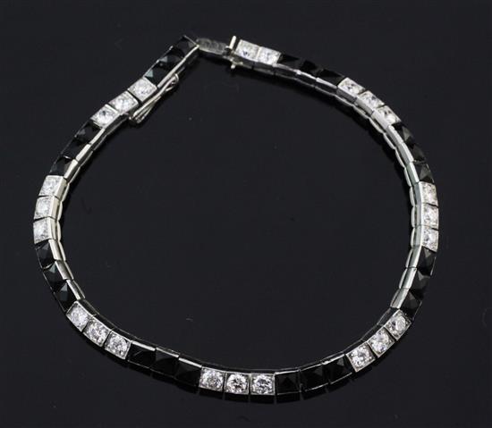 A 1920s/1930s Cartier, platinum, diamond and onyx line bracelet, 7.25in.